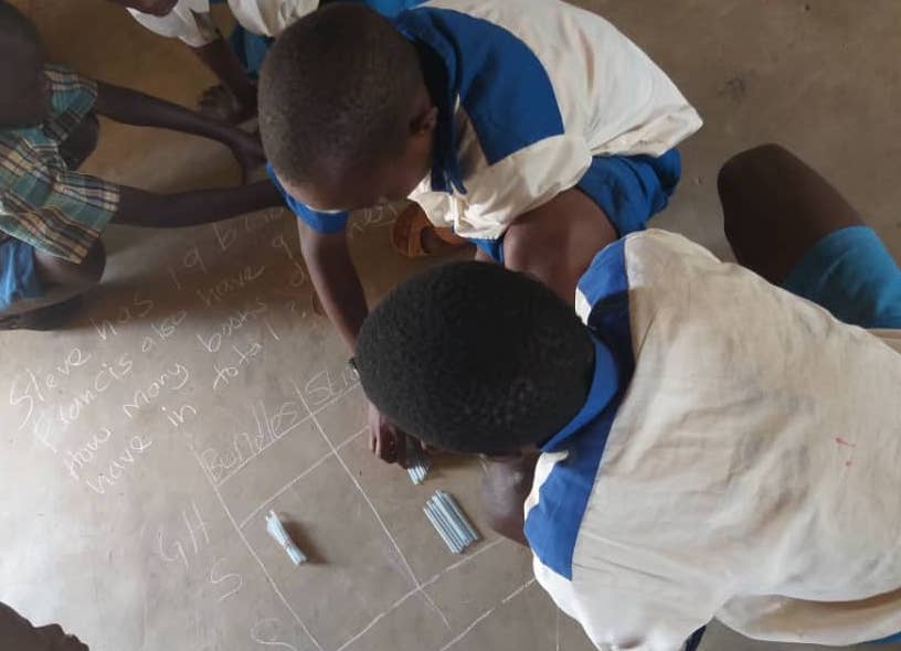 Children in Bungoma use bundles and sticks to solve a maths problem during a TaRL practice session in Bungoma, Kenya.