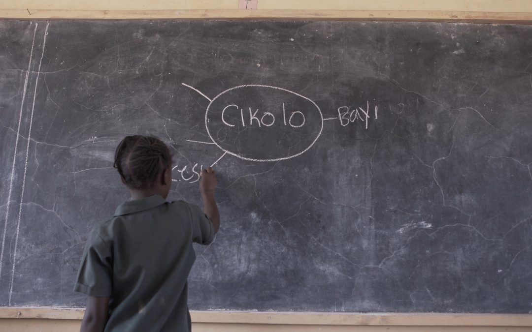 A child fills in a mind map on the board during a Catch Up activity in Zambia.