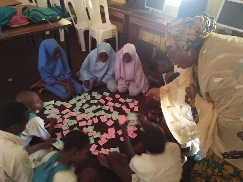 Children in a classroom in Nigeria do a TaRL flash card activity.