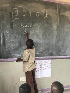 A child writes on the board during a Catch Up class in Kazungula.