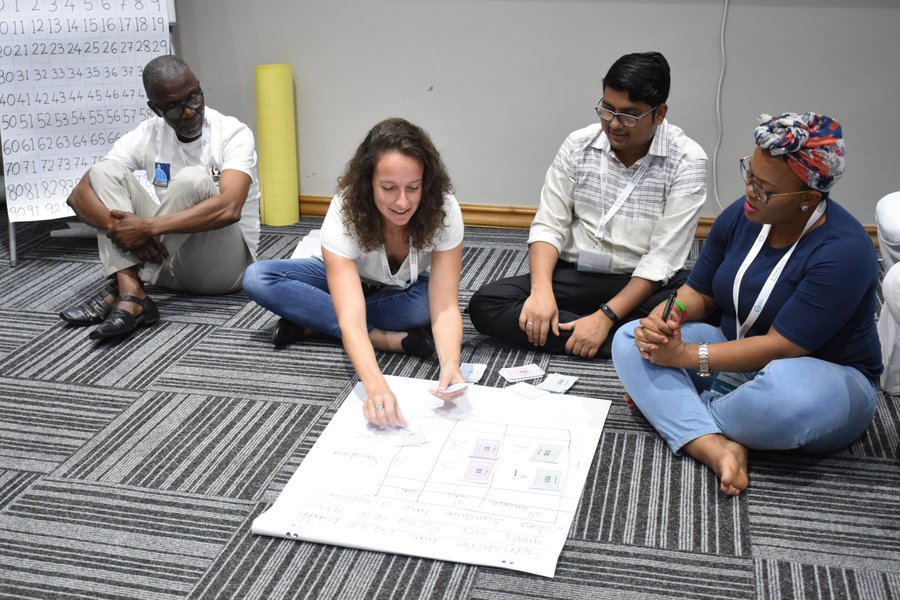 Participants at the TaRL Workshop 2019 practice solving a sum using play money during the TaRL Workshop 2019.