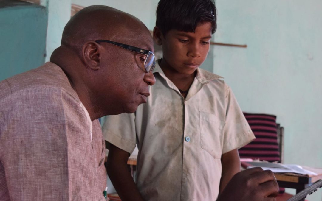 Mr. Mahuba Hazemba reads with a child in India during a learning journey to see a Pratham Teaching at the Right Level (TaRL) programme.